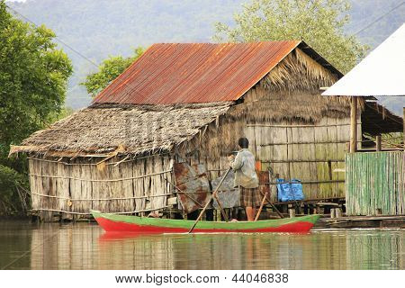 REAM, CAMBODIA - DECEMBER 9: An unidentified man rows his boat through water village on December 9,