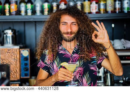 Handsome Smiling Curly Hair Bartender Preparing Cocktail At The Resort Bar