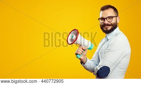 Horizontal Fofo Of Handsome Caucasian Male Holding Megaphone While Smiling, Isolated Over Yellow Bac