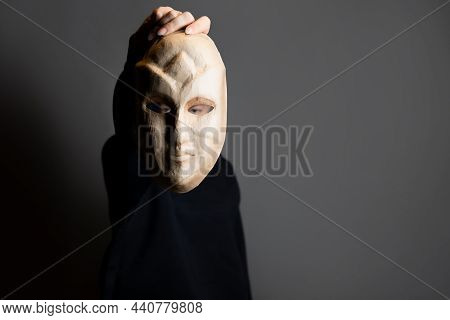 Hiding Behind A Mask, A Young Woman In A Dark Hoodie Hides Her Face With A Mask, Self-identification