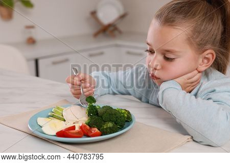 Cute Little Girl Refusing To Eat Dinner In Kitchen
