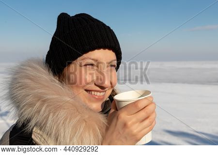 Close-up Detail Portrait Of Young Adult Beautiful Woman Wear Warm Jacket And Knitted Hat Hold Paper 