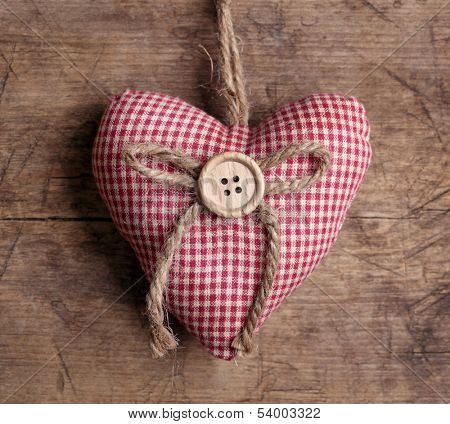 Heart with button on on wooden background