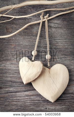 Two wooden hearts on grey background