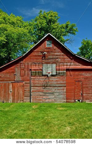 Basketball hoop on an old red barn