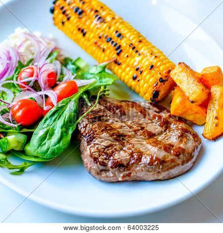 Grilled Beef Steak With Some Sallad On The Side And Corn