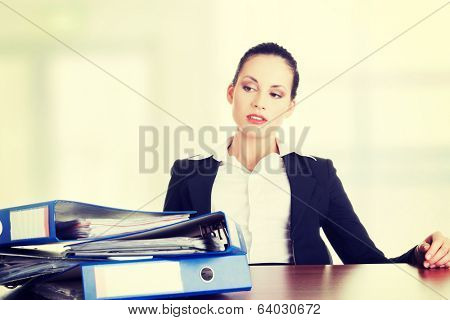 Sad woman with ringbinders sitting at the desk. Tired and exhousted business woman. 