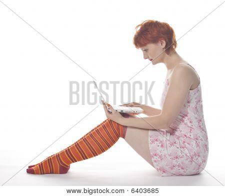 Red meisje in stripe sokken met laptop op witte achtergrond
