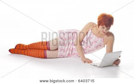 Red meisje in stripe sokken met laptop op witte achtergrond
