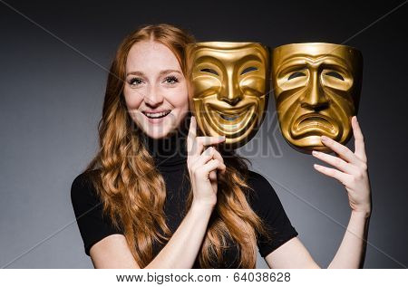 Redhead woman iwith masks in hypocrisy consept against grey background
