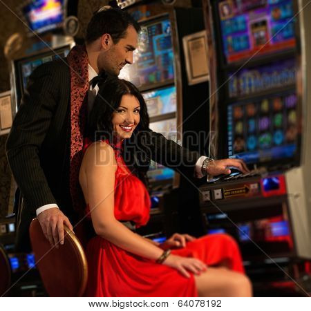 Beautiful young couple near slot machine in a casino
