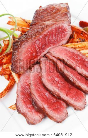 meat food : rare beef on potato chips with pepper and tomatoes over plate isolated on white background