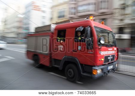 MADRID, SPAIN - OCTOBER 10, 2014: A fire truck speeding through the streets of Madrid. Due to Spanish law, only police use blue lights and ambulances and fire engines have to use amber lights.