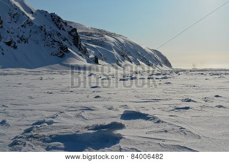 Arktic  Chukotka. Cliffs Protruding From The Snow.