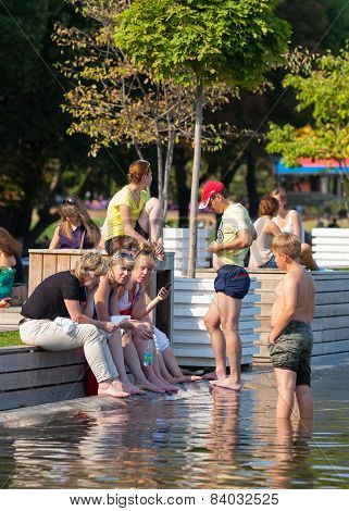 People Standing On The Shore Of A Pond