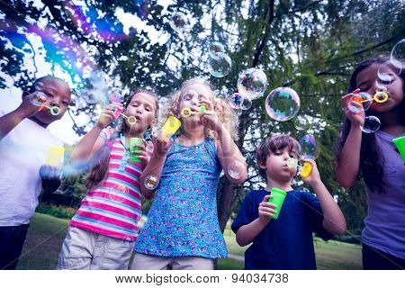 Children playing with bubble wand in the park on a sunny day