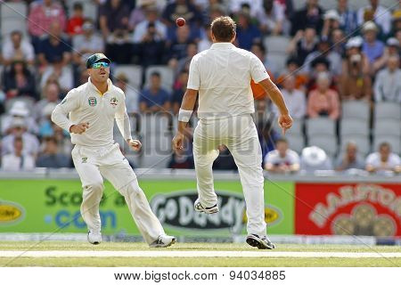 MANCHESTER, ENGLAND - August 03 2013: Ryan Harris kicks the ball in the air to David Warner during day three of  the Investec Ashes 3rd test match at Old Trafford Cricket Ground, on August 03, 2013