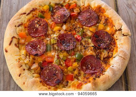Delicious Baked Salami Pizza Served On Rustic Wooden Table