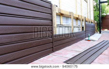 Installation Of Brown Plastic Siding On The Facade