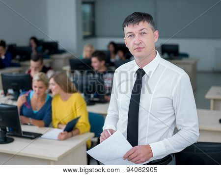 group of students with teacher in computer lab classrom learrning lessons,  get help and support