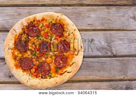 Delicious Baked Salami Pizza Served On Rustic Wooden Table