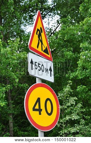 road signs speed limit and a repair the road