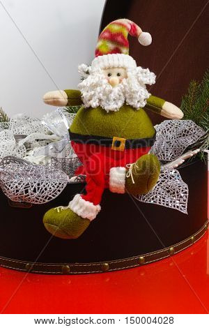 Santa Claus sits on vintage brown coffer with white Christmas tree decoration copy space