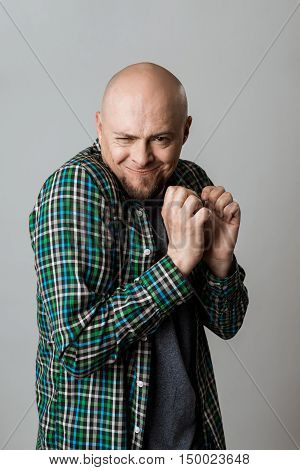 Vicious emotional man in shirt posing over beige background. Copy space.