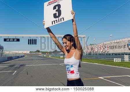 Moscow region, Russia - 27 August : route Moscow raceway girl model with long hair and a white t-shirt bears a sign with the time on the track before the race riders in day of Russian cinema 27 August, 2016.