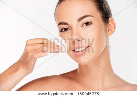 Skin care woman removing face makeup with cotton swab pad isolated on a white background