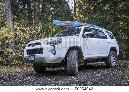 CRYSTAL, CO, USA - SEPTEMBER 28, 2016: Toyota 4Runner SUV (2016 Trail edition) carrying  a paddleboard on a back country road in Colorado's Rocky Mountains