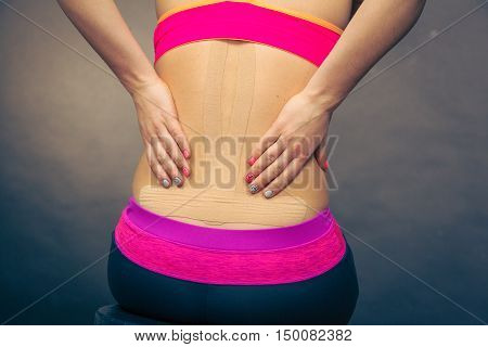 Woman With Medical Kinesio Taping On Back