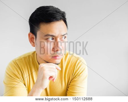 Asian man in yellown shirt seriously thinking Asian man crossed arm.