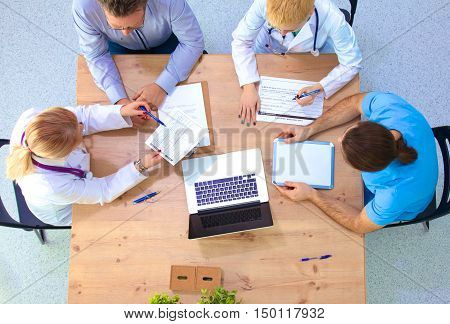 Male and female doctors working on reports in medical office.