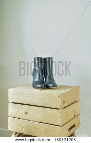 High heel boots on wooden box in walk in closet
