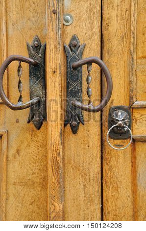 The iron doorhandle on the wooden doors