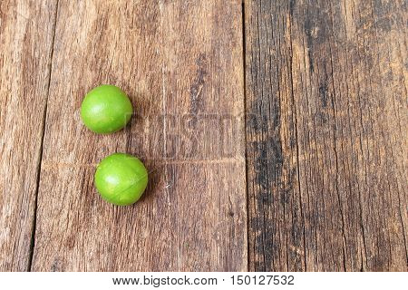 lemon with green on the wooden table top view