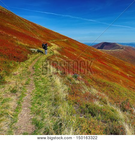 Adventure man hiking wilderness mountain with backpack and taking a picture outdoor lifestyle survival vacation