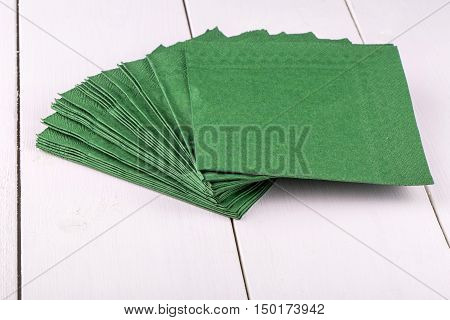 New green napkins on a white wooden dinner table
