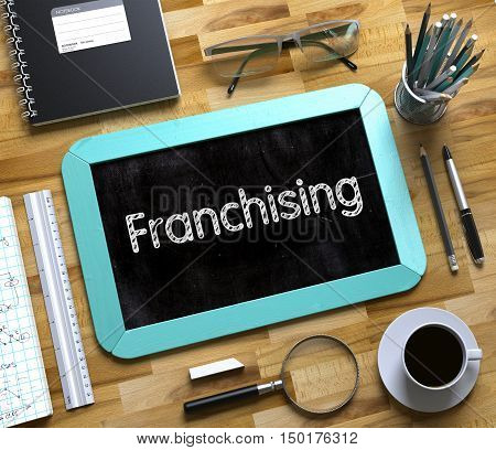 Franchising on Small Chalkboard. Franchising Handwritten on Mint Small Chalkboard. Top View of Wooden Office Desk with a Lot of Business and Office Supplies on It. 3d Rendering.