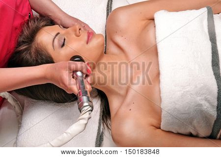 Young woman getting face Radio frequency therapy treatment in beauty center and spa