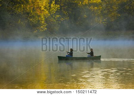 mother and daughter canoeing in autumn colors