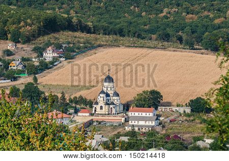 Landscape view with Capriana Monastery and the village around. Winter Church visible at center was built in Neo-Byzantine style in 1903. Capriana Orthodox Christian Monastery is one of the oldest