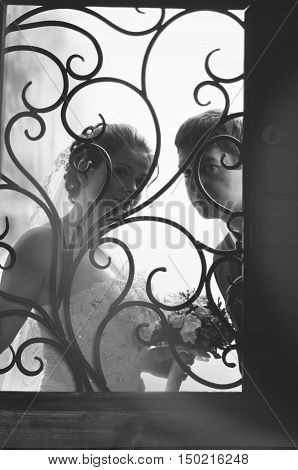 Wedding couple looling froom wrought gate at wedding