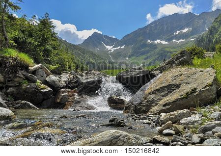Scene with mountain stream in summer season. Small cascade on mountain river in Carpathian Mountains