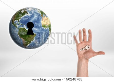 Human hand with the key from planet Earth. Enviroment protection. Protection of Nature. Resource usage. Elements of this image are furnished by NASA.
