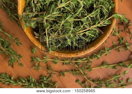 Fresh Thyme into a bowl over a wooden table