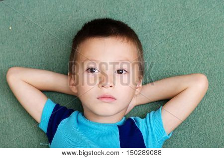 thoughtful child portrait lying on crossed arms