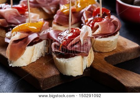 Spanish Tapas With Slices Jamon Serrano And Grilled Pepper. Also Olives, Salami, Pickled Onions, And