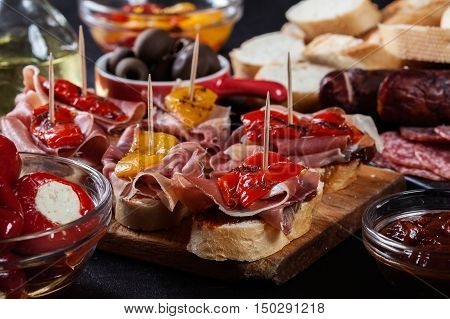 Spanish Tapas With Slices Jamon Serrano And Grilled Pepper. Also Olives, Salami, Pickled Onions, And